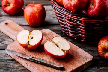 red ripe apples in a basket on a wooden background