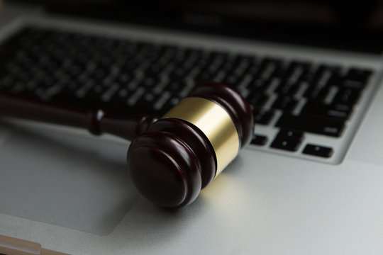 cyber law or crime internet concept. judges gavel on keyboard laptop computer.