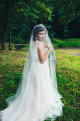 Obraz na płótnie Canvas Bride with a glass of champagne under the veil