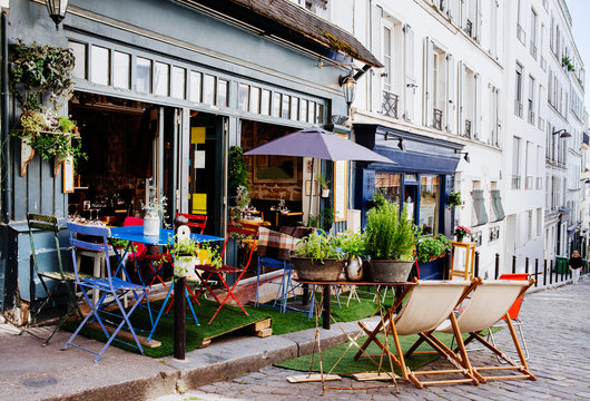 Cozy street with tables of cafe in quarter Montmartre in Paris, France