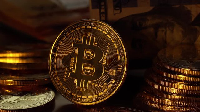 Bitcoin coin is glowed with golden light and gradually fades. Macro shot. 4K looped video.
