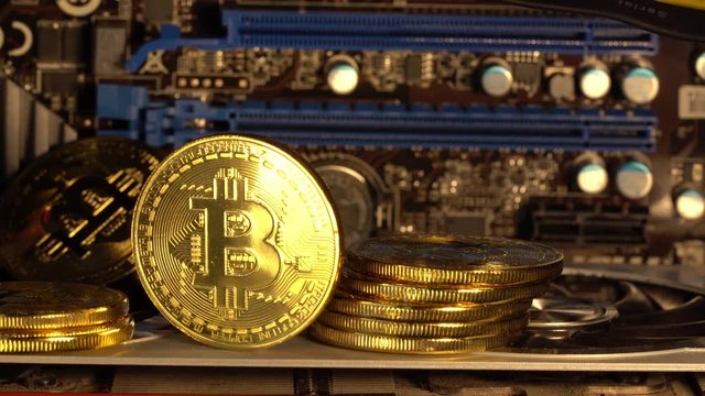Bitcoin coin is glowed with golden light and gradually fades. Macro shot. 4K looped video.
