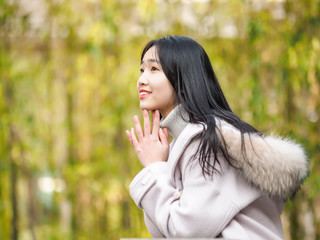 Portrait of beautiful young brunette woman in white winter coat. Outdoor fashion portrait of glamour young Chinese teenage stylish lady. Emotions, people, beauty and lifestyle concept.