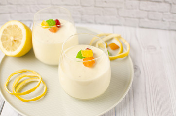 Sweet lemon mousse with candied fruits in glasses