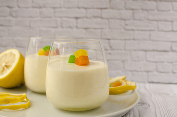 Sweet lemon mousse with candied fruits in glasses