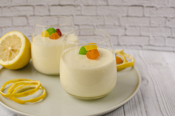 Sweet lemon mousse with candied fruits in glasses