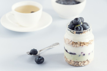 Serving of Yogurt with Whole Fresh Blueberries Oatmeal and Matcha Powder Healthy Diet Food Breakfast Toned Cup of Tea