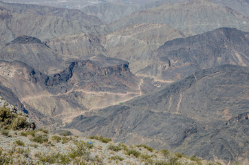 Windy gravel road through valley in mountains in Oman. Extremely deserted place no trees at all.