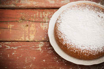 chocolate sponge cake on old wooden background.