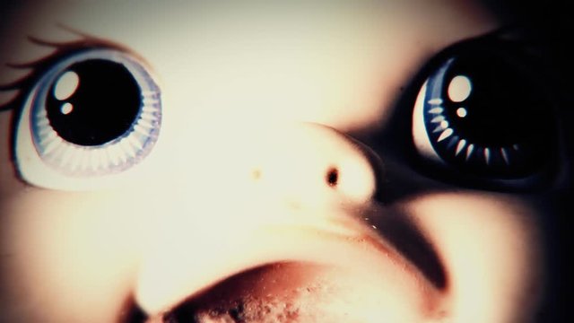 The disturbing face of a doll over changing lights.
