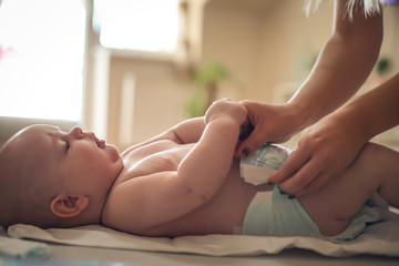 Mother changing her baby boy.