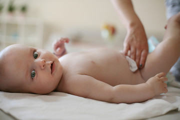 Mother changing her baby boy.