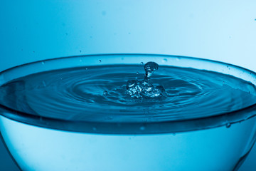 The splashes of water on the background of blue light