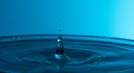 The splashes of water on the background of blue light