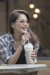 younger woman drinking cool beverage in plastic bottle