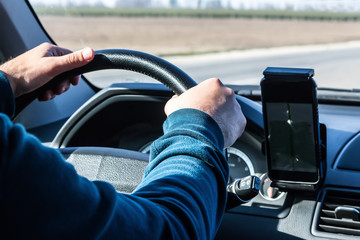 driver's hand on the steering wheel of a driving car
