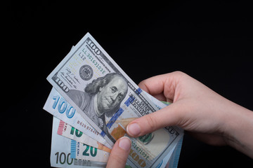 Hand holding American dollar  isolated on black background