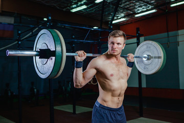 Fototapeta na wymiar Muscular fitness man preparing to deadlift a barbell over his head in modern fitness center.Functional training.Snatch exercise. Cross fit style, deadlift
