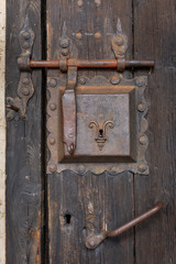 Altes verrostetes Türschloss mit Riegel in einer Holztür, Detail