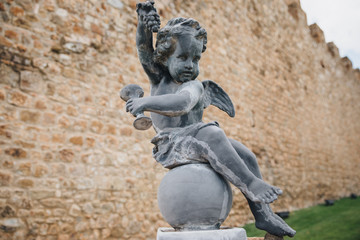 statue stands against the background of an old castle in Italy