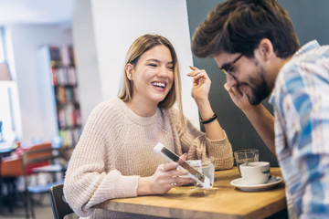 Young couple in indoor cafe using digital tablet