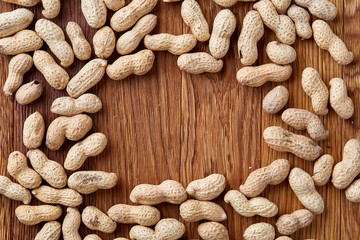 Unpeeled peanuts on a wooden background, top view, selective focus, shallow depth of field.