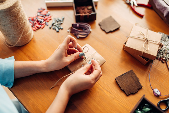 Female person tie a bow on a gift box, needlework