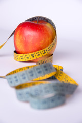 apple and sewing tape centimeter on a white background