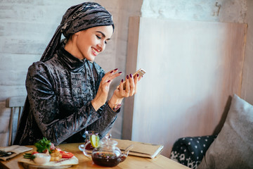 muslim women holding smartphonephone. thinking of good memories. serfing social media