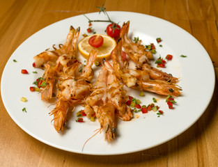 Roasted Royal Prawns with Cherry tomatoes and Greek spices. On a wooden background. Top view. Free space