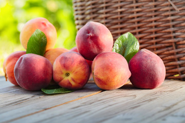 Fresh peaches with leaves  on wooden rustic background.