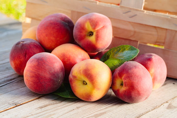 Fresh peaches with leaves  on wooden rustic background.
