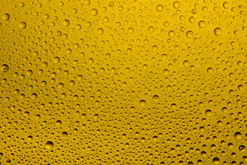 Yellow water drops on glass. Background.