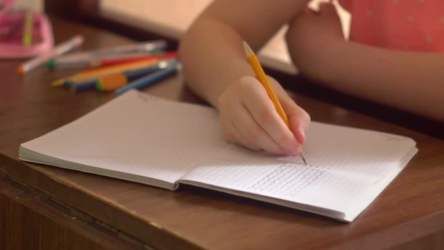 concentrated learning girl drawing in a exercise-book
