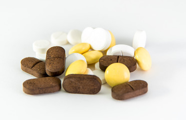 Several pills lying on a white background or on a medical book with graphs