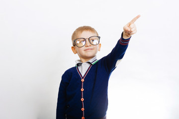 Cheerful little young boy wearing eyeglasses and pointing away over white background