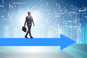 Fototapeta premium Businessman walking on arrow in business concept
