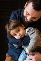 Little boy in father hugs