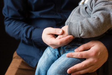 Hands of baby boy and adult man close-up