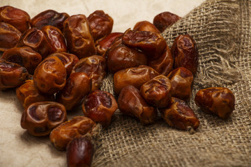 Dried dates on a wooden table in silver dishes close-up. Dates dried dried fruits in the diet chelovenka. Dates.
