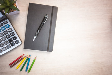 Wood office desk table with notebook and pen , cup of coffee.Top view with copy space.