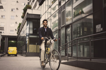 Fototapeta na wymiar Smiley businessman driving bike on street.