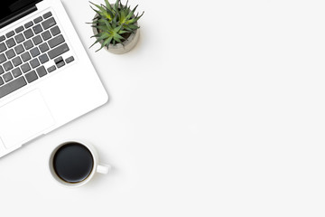 White office desk table with laptop computer and cup of coffee. Top view with copy space, flat lay.