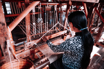 The local Intha woman weaving the lotus cloth with the hand loom at the local lotus cloth weaving...