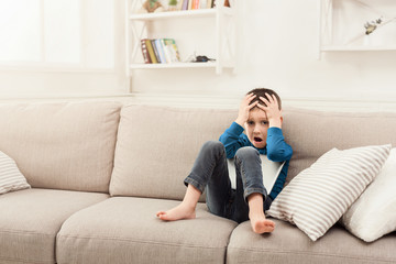 Upset boy with digital tablet at home