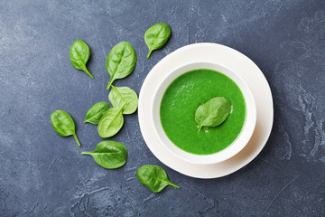 Creamy spinach soup in bowl on black table top view. Diet food.