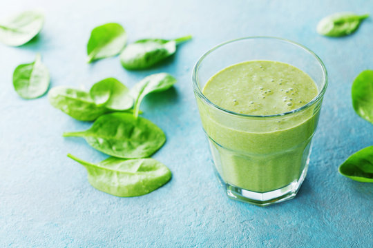 Green spinach smoothie in glass for healthy breakfast.