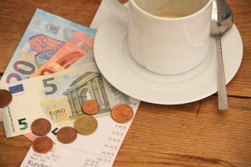 leere Kaffeetasse mit einer Rechnung