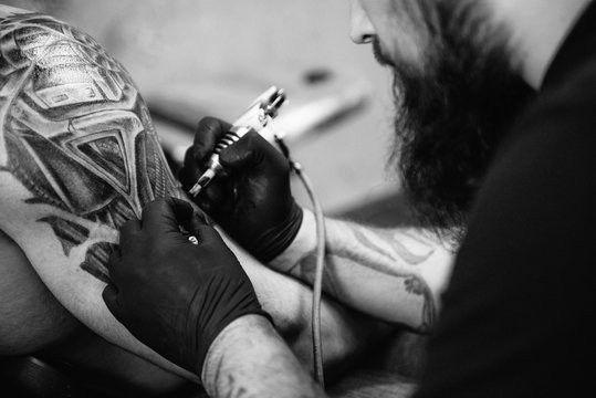 the process of creating a tattoo on the back of a man
