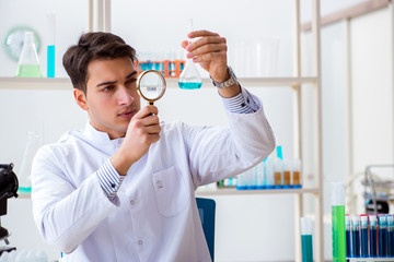 Naklejka premium Young chemist student working in lab on chemicals